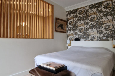 Imagen de dormitorio principal y beige y blanco clásico renovado de tamaño medio sin chimenea con paredes beige, suelo laminado, suelo beige y papel pintado