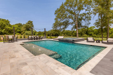 Example of a large backyard stone and custom-shaped lap hot tub design in Other