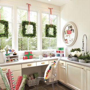 Photo of a mid-sized eclectic craft room in Minneapolis with white walls, slate floors, a built-in desk and grey floor.