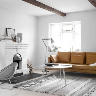 Свежая идея для дизайна: гостиная комната в скандинавском стиле с белыми стенами, светлым паркетным полом, камином и фасадом камина из кирпича - отличное фото интерьера