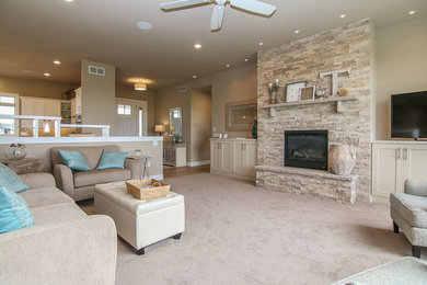 Inspiration for a large coastal open concept carpeted and beige floor living room remodel in Other with beige walls, a standard fireplace, a stone fireplace and a tv stand