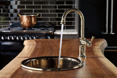 Example of a mid-sized trendy kitchen design in New York with wood countertops, black backsplash, subway tile backsplash and an island