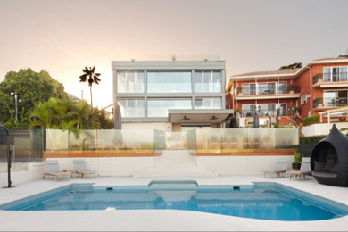 Photo of a large beach style backyard custom-shaped pool in Sydney.