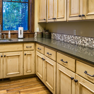 Photo of a large rustic u-shaped separated utility room in Other with a submerged sink, recessed-panel cabinets, distressed cabinets, granite worktops, beige walls, medium hardwood flooring and a side by side washer and dryer.