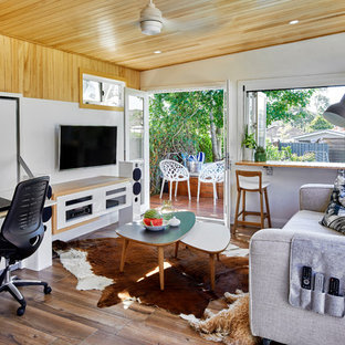 Idee per un piccolo soggiorno minimal aperto con pareti bianche, pavimento in legno massello medio e TV a parete