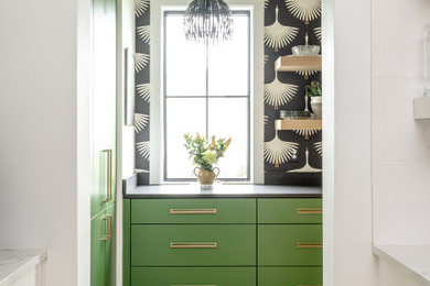 Inspiration for a transitional light wood floor and vaulted ceiling kitchen remodel in Charleston with a farmhouse sink, flat-panel cabinets, white cabinets, quartz countertops, white backsplash, ceramic backsplash, paneled appliances, an island and black countertops