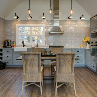 Small farmhouse kitchen pantry remodeling - Small farmhouse l-shaped vinyl floor kitchen pantry photo in Calgary with a farmhouse sink, raised-panel cabinets, gray cabinets, quartz countertops, gray backsplash, porcelain backsplash and stainless steel appliances