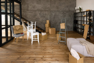 Example of a huge urban walk-out medium tone wood floor, brown floor and wall paneling basement design in Edmonton with gray walls