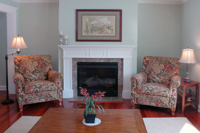 Example of a classic formal and enclosed medium tone wood floor living room design in Minneapolis with blue walls, a standard fireplace, a plaster fireplace and no tv