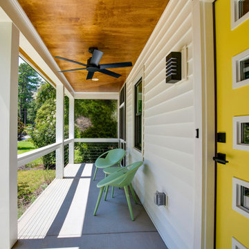 Modern Covered Porch with Yellow Door and Wood Ceiling