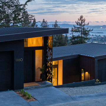Standing seam metal roof and dark vertical cladding on a Berkeley Hills new cons
