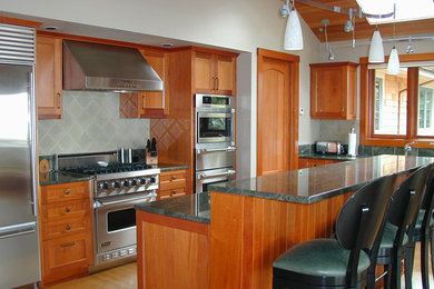 Inspiration for a large transitional u-shaped bamboo floor open concept kitchen remodel in Seattle with an undermount sink, shaker cabinets, medium tone wood cabinets, granite countertops, ceramic backsplash, stainless steel appliances, an island and gray backsplash