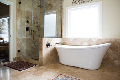 Inspiration for a mid-sized mediterranean master bathroom in Other with travertine floors, brown tile, brown walls, a freestanding tub, a corner shower, stone tile, brown floor and a hinged shower door.