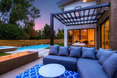 Inspiration for a large contemporary backyard concrete paver patio kitchen remodel in Denver with a pergola