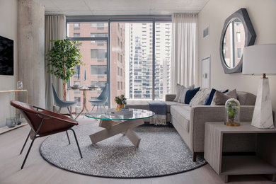 Example of a mid-sized trendy open concept light wood floor living room design in Chicago with beige walls and a wall-mounted tv