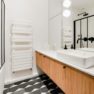 Ejemplo de cuarto de baño principal, contemporáneo, de tamaño medio, con armarios con paneles lisos, puertas de armario de madera clara, bañera encastrada sin remate, combinación de ducha y bañera, baldosas y/o azulejos blancos, baldosas y/o azulejos de terracota, paredes blancas, suelo de azulejos de cemento, lavabo sobreencimera, encimera de cuarcita, suelo negro, ducha con puerta con bisagras y encimeras beige