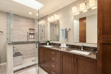 Example of a mid-sized minimalist master beige tile and porcelain tile laminate floor, gray floor and double-sink bathroom design in Seattle with shaker cabinets, brown cabinets, a two-piece toilet, an undermount sink, quartz countertops, a hinged shower door, brown countertops and a built-in vanity