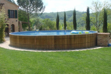 Inspiration for a mediterranean side yard concrete paver and round aboveground pool remodel in New York