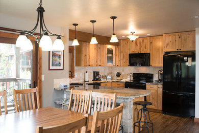 Inspiration for a mid-sized modern medium tone wood floor and brown floor eat-in kitchen remodel in Denver with a double-bowl sink, recessed-panel cabinets, light wood cabinets, marble countertops, beige backsplash, ceramic backsplash, black appliances and a peninsula