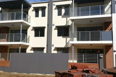 Photo of an expansive modern three-storey brick apartment exterior in Perth.