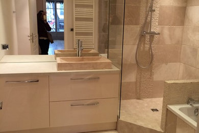 Cette image montre une petite salle d'eau design avec un placard avec porte à panneau encastré, des portes de placard beiges, une baignoire encastrée, une douche ouverte, un carrelage beige, du carrelage en marbre, un mur beige, un sol en marbre, un lavabo posé et un plan de toilette en bois.