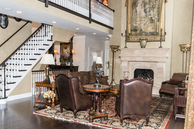 Example of a large arts and crafts formal and open concept dark wood floor and brown floor living room design in Chicago with beige walls, a standard fireplace, a stone fireplace and no tv