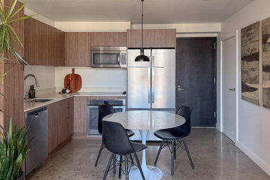 Example of a small trendy l-shaped concrete floor and gray floor eat-in kitchen design in Miami with a single-bowl sink, flat-panel cabinets, medium tone wood cabinets, quartzite countertops, stainless steel appliances, no island and beige countertops