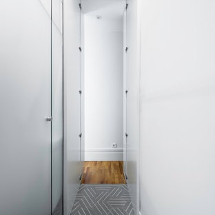 マドリードの大きいトランジショナルスタイルのおしゃれな家事室 (アンダーカウンターシンク、落し込みパネル扉のキャビネット、白いキャビネット、グレーの壁、セラミックタイルの床、目隠し付き洗濯機・乾燥機、ターコイズの床) の写真