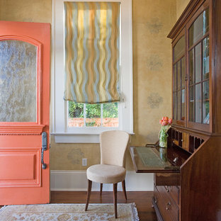 ニューオリンズの片開きドアトラディショナルスタイルのおしゃれな玄関 (黄色い壁、濃色無垢フローリング、オレンジのドア) の写真