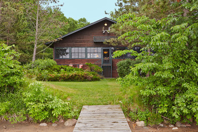This is an example of a mid-sized country two-storey brown house exterior in Minneapolis with wood siding, a gable roof and a shingle roof.