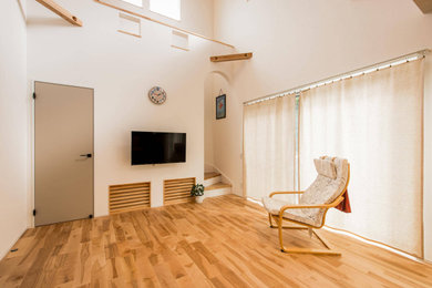 Modelo de salón abierto y blanco mediterráneo con paredes beige, suelo de madera en tonos medios, televisor colgado en la pared, suelo beige, papel pintado y papel pintado