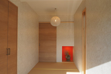 他の地域にある広い和風のおしゃれな玄関ホール (白い壁、畳、淡色木目調のドア、ベージュの床、クロスの天井、壁紙) の写真