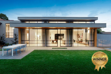 This is an example of a large contemporary split-level house exterior in Melbourne with wood siding.