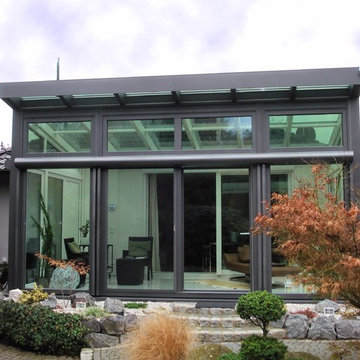 Moderner Wintergarten mit umgekehrtem Pultdach