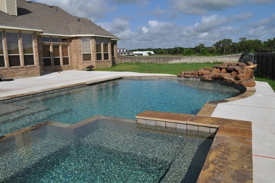 Inspiration for a large timeless backyard concrete and custom-shaped lap hot tub remodel in Austin