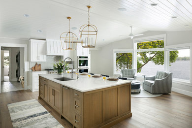 Inspiration for a large coastal l-shaped brown floor, vaulted ceiling and light wood floor eat-in kitchen remodel in Minneapolis with an undermount sink, shaker cabinets, white cabinets, quartz countertops, gray backsplash, subway tile backsplash, paneled appliances, an island and white countertops