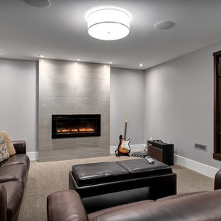 カルガリーのコンテンポラリースタイルのおしゃれな地下室 (グレーの壁、カーペット敷き、標準型暖炉、タイルの暖炉まわり) の写真