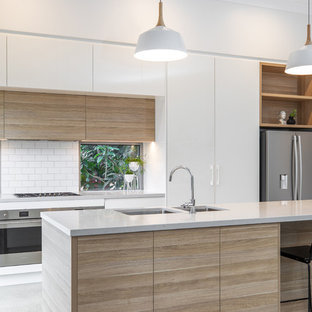 Mid-sized contemporary kitchen pantry remodeling - Kitchen pantry - mid-sized contemporary galley concrete floor and gray floor kitchen pantry idea in Adelaide with an undermount sink, flat-panel cabinets, light wood cabinets, quartz countertops, white backsplash, subway tile backsplash, stainless steel appliances, an island and gray countertops