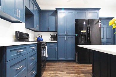 ヒューストンにある広いカントリー風のおしゃれなキッチン (アンダーカウンターシンク、青いキャビネット、御影石カウンター、白いキッチンパネル、セラミックタイルのキッチンパネル、黒い調理設備、クッションフロア、茶色い床、白いキッチンカウンター) の写真