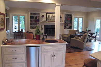 Inspiration for a mid-sized timeless galley medium tone wood floor and brown floor wet bar remodel in Other with a drop-in sink, raised-panel cabinets, white cabinets and tile countertops