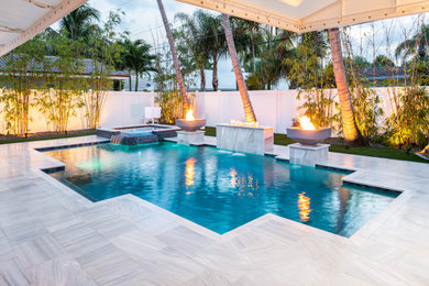Design ideas for a mid-sized modern backyard custom-shaped pool in Miami with a water feature.