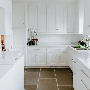 Photo of a medium sized contemporary l-shaped separated utility room in Baltimore with a double-bowl sink, shaker cabinets, white cabinets, white walls, slate flooring, a side by side washer and dryer, brown floors and white worktops.