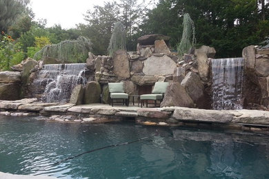 Example of a large arts and crafts backyard stone and custom-shaped natural pool fountain design in New York