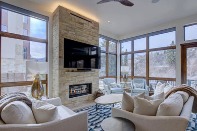 Family room - large contemporary open concept medium tone wood floor and brown floor family room idea in Other with white walls, a standard fireplace, a stacked stone fireplace and a wall-mounted tv