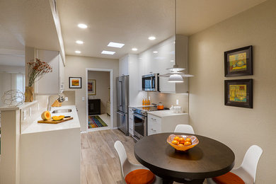 Small minimalist galley porcelain tile enclosed kitchen photo in Phoenix with an undermount sink, flat-panel cabinets, white cabinets, quartz countertops, beige backsplash, subway tile backsplash, white appliances and no island