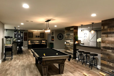 Inspiration for a large transitional underground light wood floor and beige floor basement game room remodel in Other with beige walls