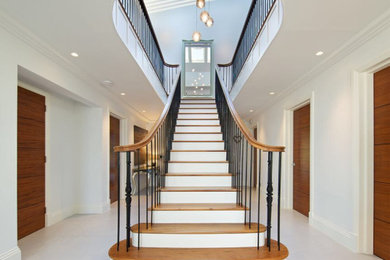 Inspiration for a large traditional wood curved mixed railing staircase in London with wood risers.