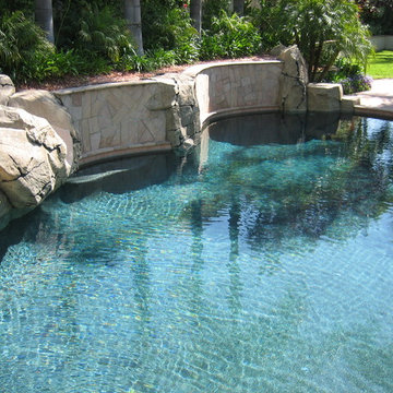 Pool and patio with stone / rock walls and deck