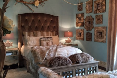 Eclectic bedroom in Dallas with blue walls and dark hardwood floors.