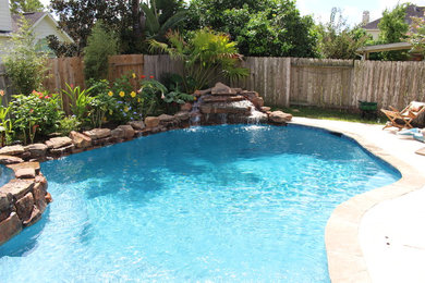 Example of a mid-sized mountain style backyard custom-shaped natural pool fountain design in Houston with decking
